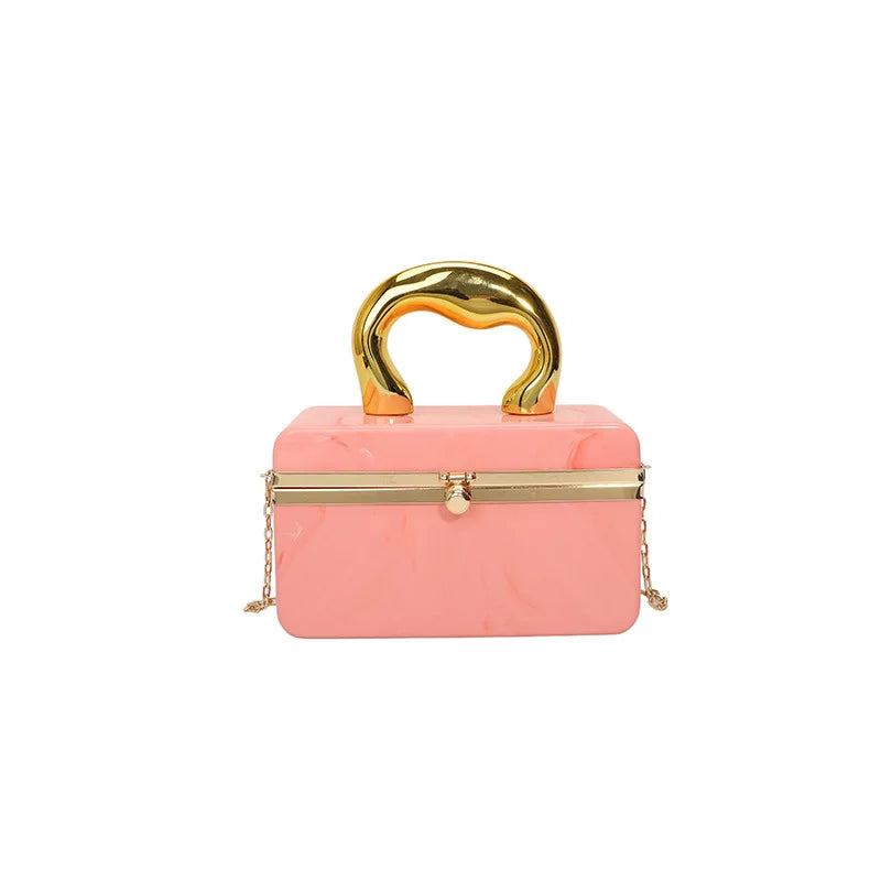 Pink handbag with gold handle and chain on a white background