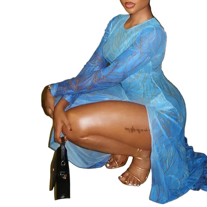Woman in a blue dress sitting on a pavement at night.