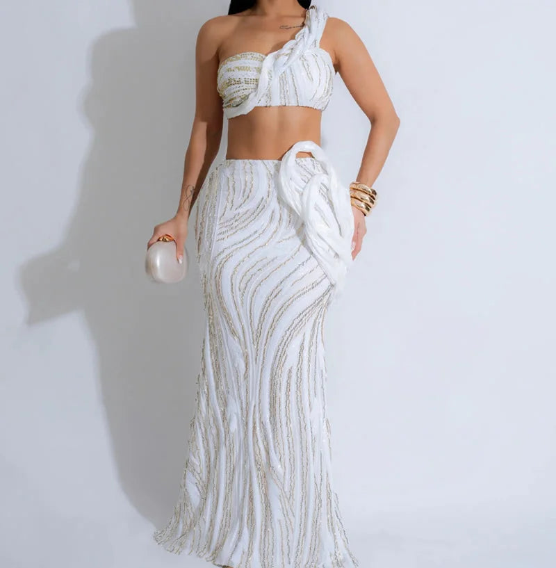 Woman wearing a white and gold sequin outfit against a light gray background