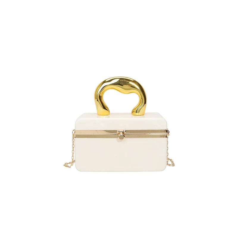 White handbag with gold handle and chain on a white background