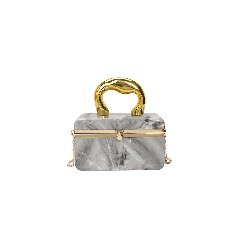 Marble-patterned handbag with gold accents on a white background