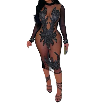 Sheer black dress with intricate designs worn by a model against a white background